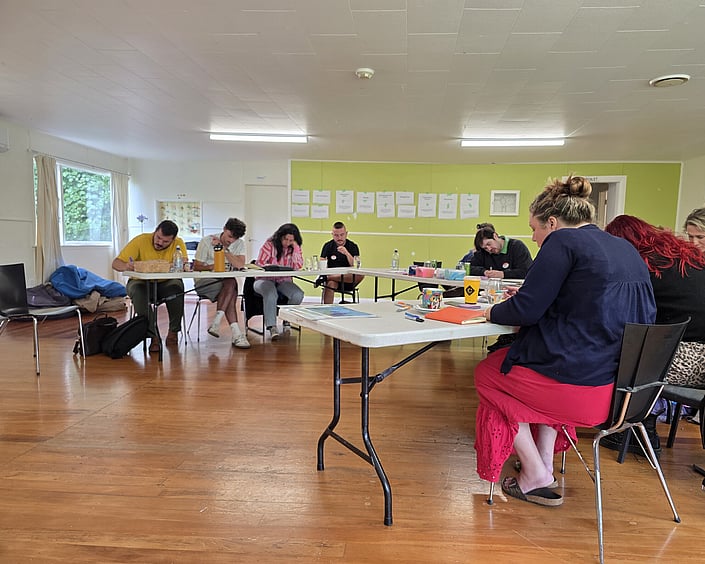 Group seated around tables working quietly on tasks during a strategy session.