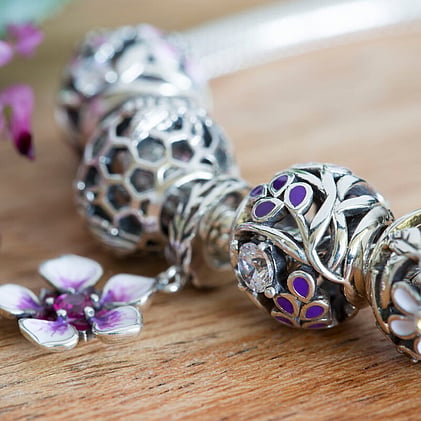 Evolve Jewellery Charm Bracelet with beads and purple flower charms.
