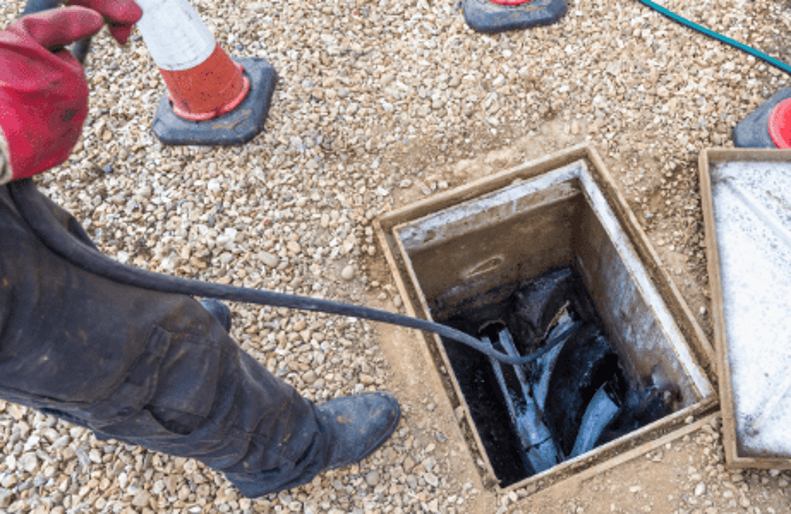 Drainage technician working in an open drainage pit