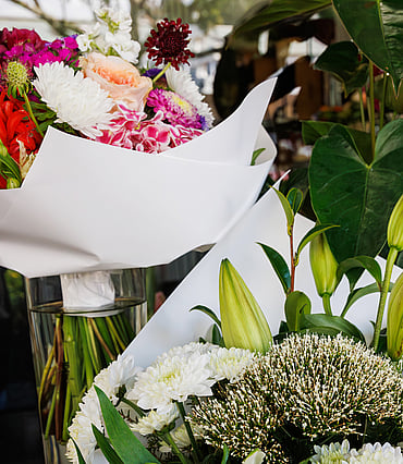 Colourful fresh flower bouquets wrapped in white paper