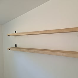 Custom timber shelving with wall brackets.