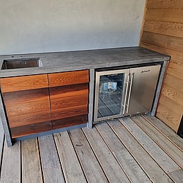 Outdoor bar, concrete tops cedar weatherboards for doors.