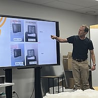 Facilitator presenting information on a large display screen during a training session
