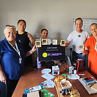 Group of people gathered around a table during a community wellbeing event