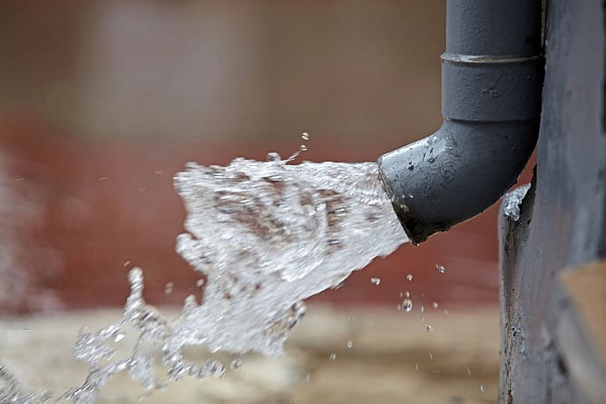 rain pouring from over loaded downpipe