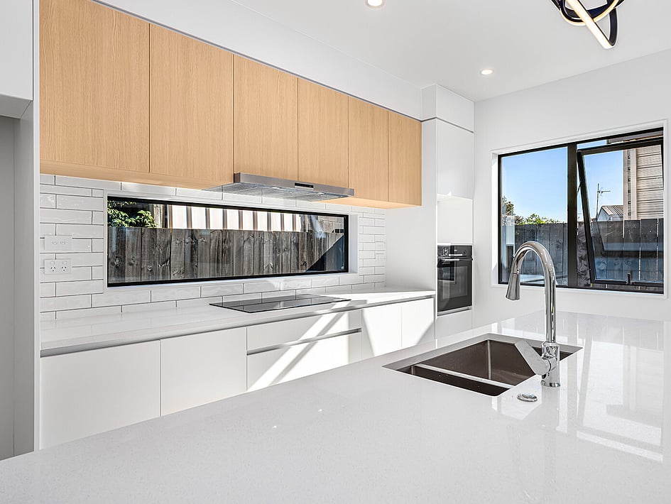 New white kitchen with timber accents in Eden Construction’s new build house on Mountain Road, Mangere Bridge, Auckland.