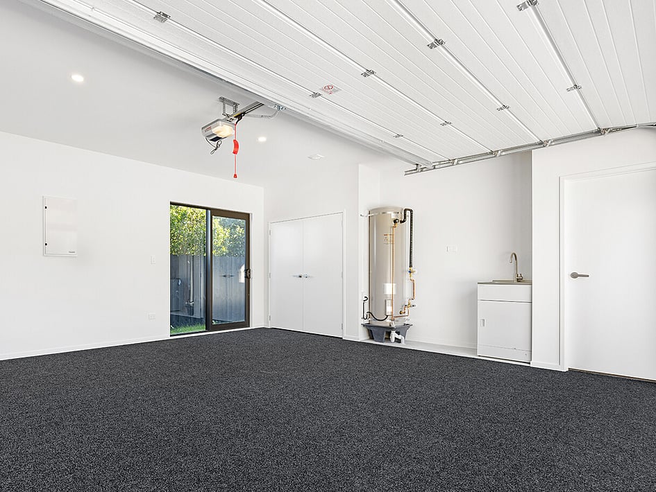 Dark carpeted garage in Eden Construction’s new build house on Mountain Road, Mangere Bridge, Auckland.