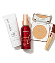 Jane Iredale primer, hydration spray, compact powder and a brush sitting on a white background