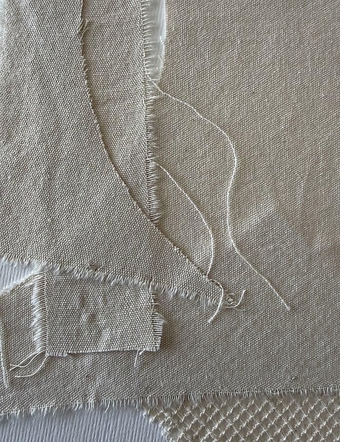 layered linen fabric close-up on fabriano paper, linen weave, texture and soft frayed edges