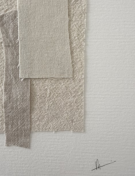 close-up image of ivory fabriano surface texture, pale beige-toned linen and cotton fragments with soft frayed edges and handwritten signature in lower right corner