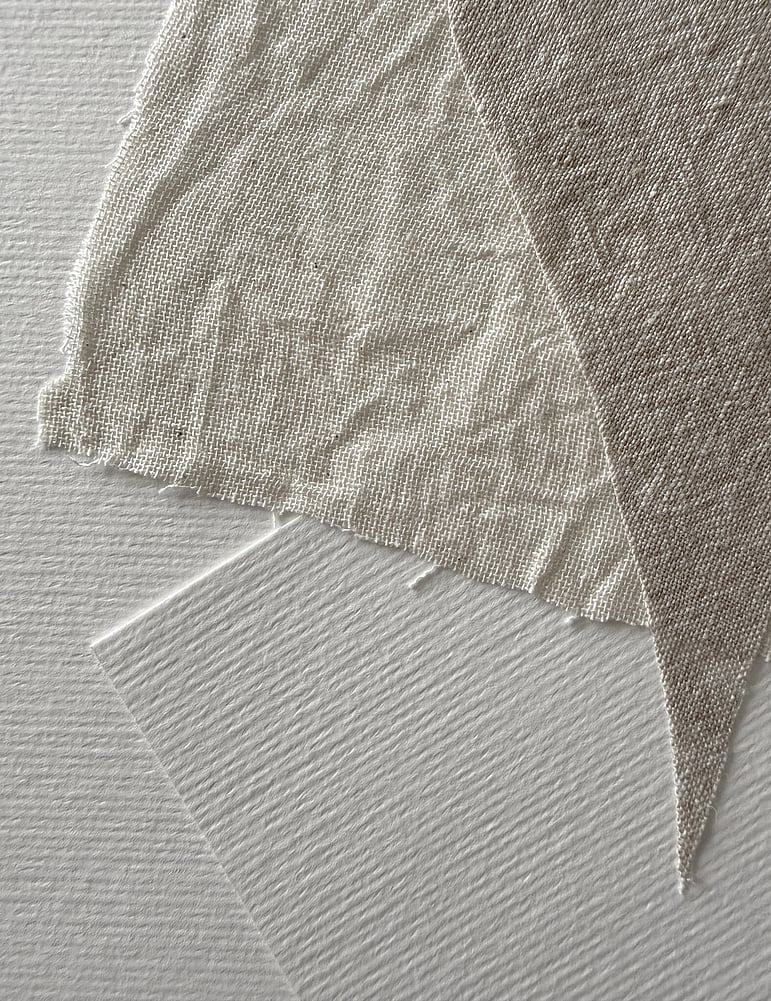 detail image of layered, beige-toned linen fragments on soft white fabriano, showing weave texture, soft frayed edges and one hand-cut squared soft white fabriano paper shape
