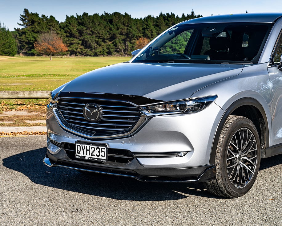 Mazda CX8 front three quarter view on grass field