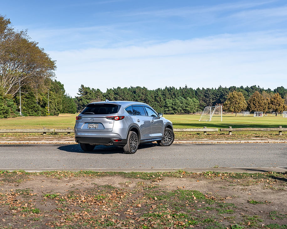 Mazda CX8 side view parked near treeline