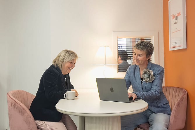 maree gately marketing consultant and social media manager at a desk in whangarei nz with photographer client, sarah warrington