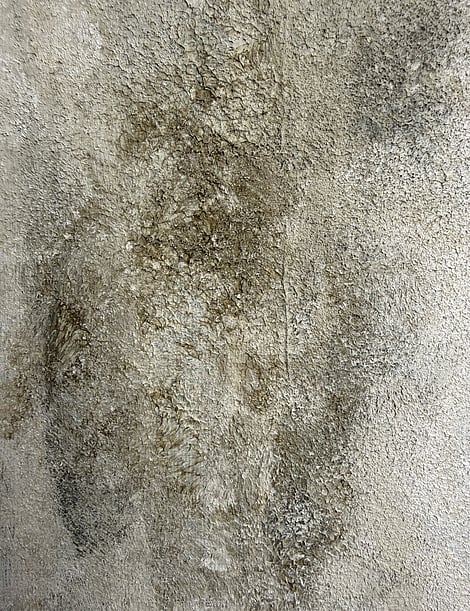 close-up of layered mineral surface with exposed underlayers, silica sand texture with charcoal, green and cream tonal variation on linen