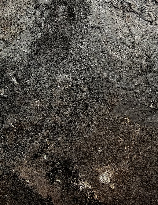 detail image showing granular texture, raised ridges, matte charcoal smudging and subtle mineral sheen