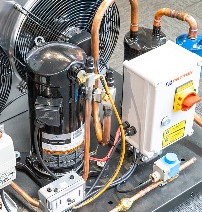 Close-up of a commercial refrigeration compressor and copper pipework