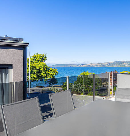 Outdoor lounge chairs on balcony overlooking Lake Taupo
