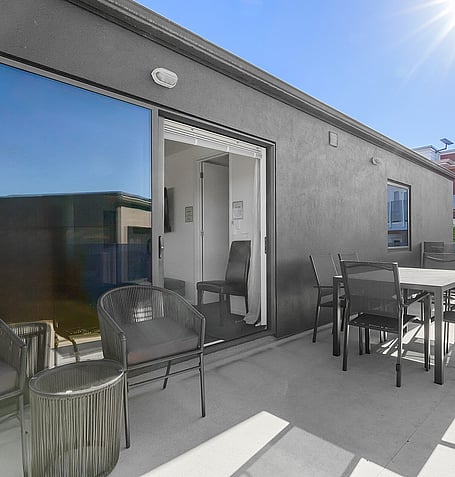 Glass-fenced deck with outdoor dining setting beside Gather Taupo