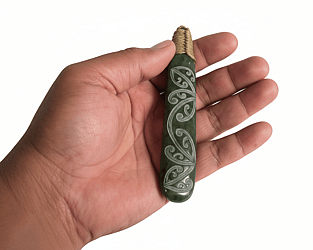 &ldquo;Pounamu (New Zealand greenstone) piece with a laser‑etched kōwhaiwhai pattern of flowing, symmetrical curving motifs inspired by traditional Māori rafter designs.&rdquo;