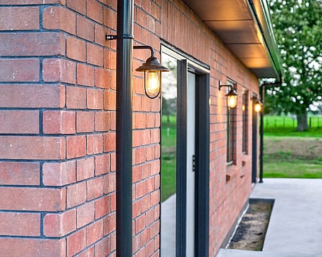Red brick home with feature lighting by Whitechurch Construction, Te Awamutu builders.