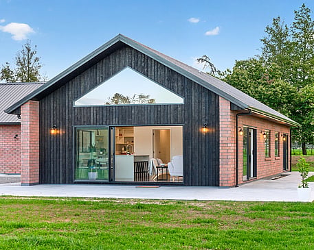 Red brick cladded home with burnt Japanese cedar feature gable. New build by Whitechurch Construction, Te Awamutu builders.