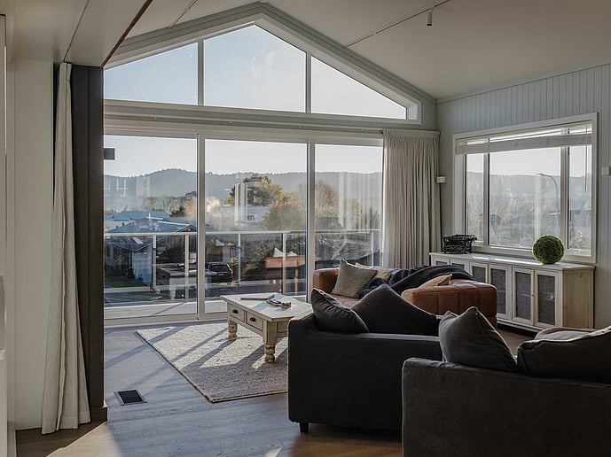 Living area with full height glass window with view of Lake Taupo
