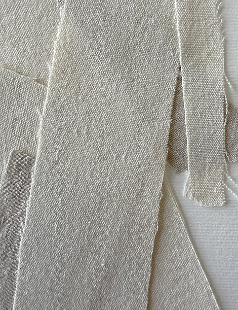detail of layered neutral-toned linen and cotton fragments, showing weave texture and soft frayed edges