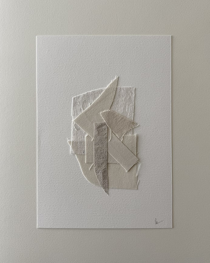 full image of layered collage of wheat-toned linen and cotton fragments on soft white fabriano, showing soft frayed edges and handwritten signature in lower right corner  