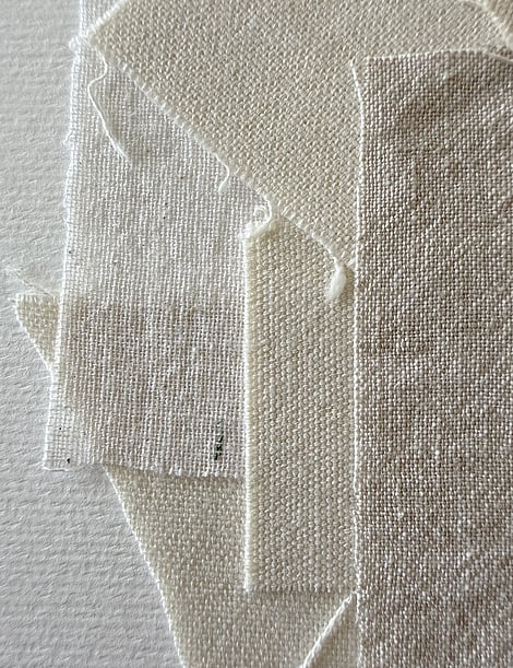 detail image of layered wheat-toned linen and cotton fragments, showing varying weave textures and soft frayed edges
