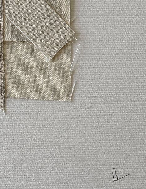 close-up image of ivory fabriano surface texture, layered cotton fragments with soft frayed edges and handwritten signature in lower right corner