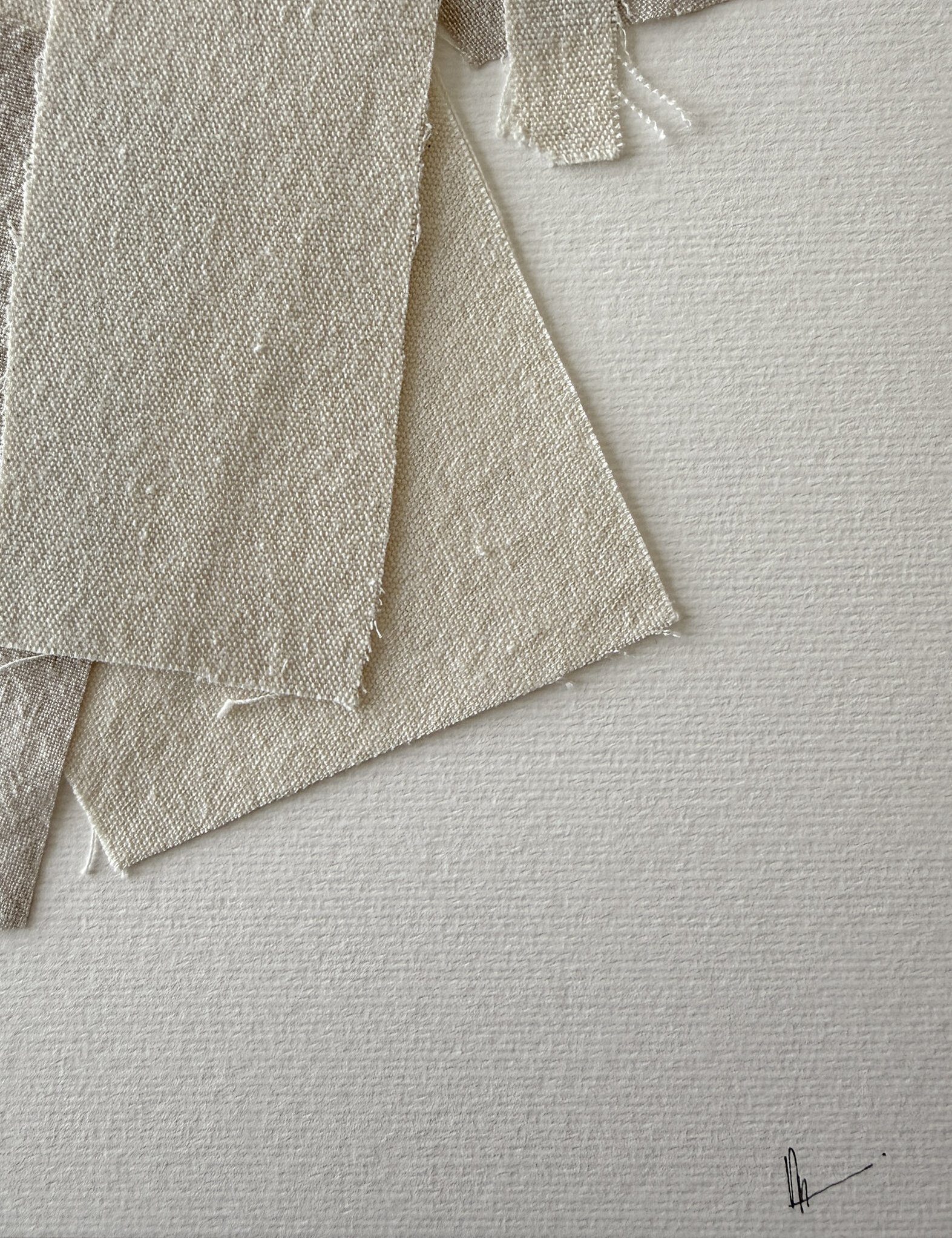 close-up image of soft white fabriano surface texture, layered cotton fragments with varied weave textures, soft frayed edges and handwritten signature in lower right corner
