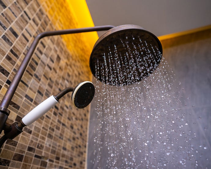 Shower running hot water supplied by an energy-efficient hot water heat pump
