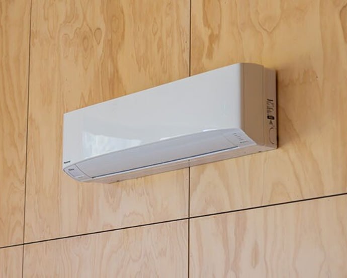 High wall air conditioning unit on a timber-lined wall