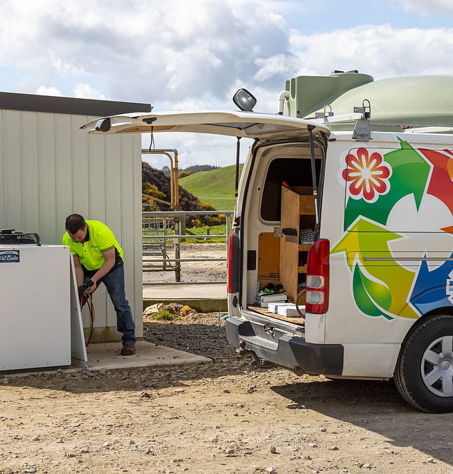 Temprite technician servicing an outdoor unit beside a company van