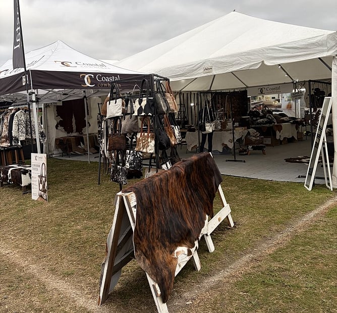 Coastal Cowhides' 10x10 marquee hire with flooring at Fieldays 2026, displaying cowhide rugs and bags