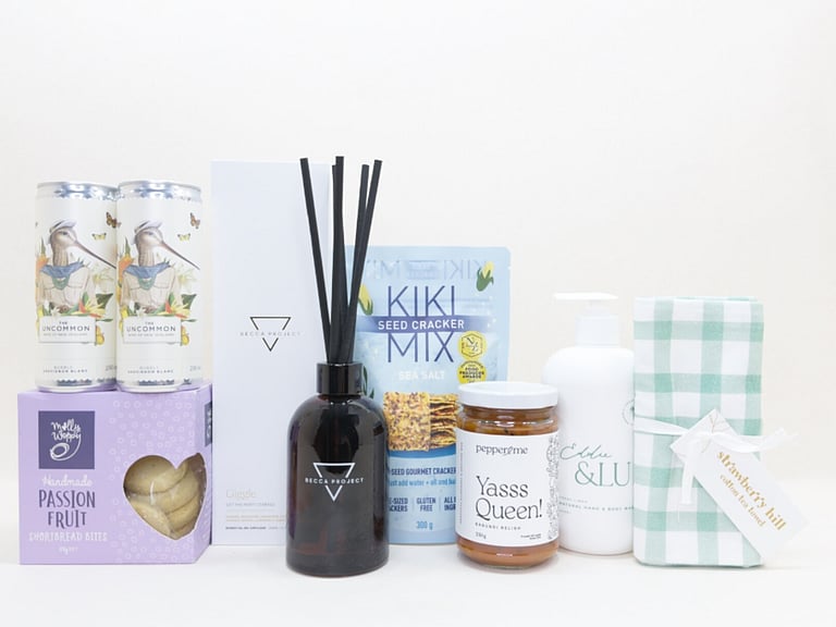 Home Treats Gift Box featuring Uncommon sparkling wine cans, Strawberry Hill tea towel, Kiki crackers, Yas Queen Relish, Molly Woppy cookies, Becca Project chocolate, and Eddy & lu home essentials.