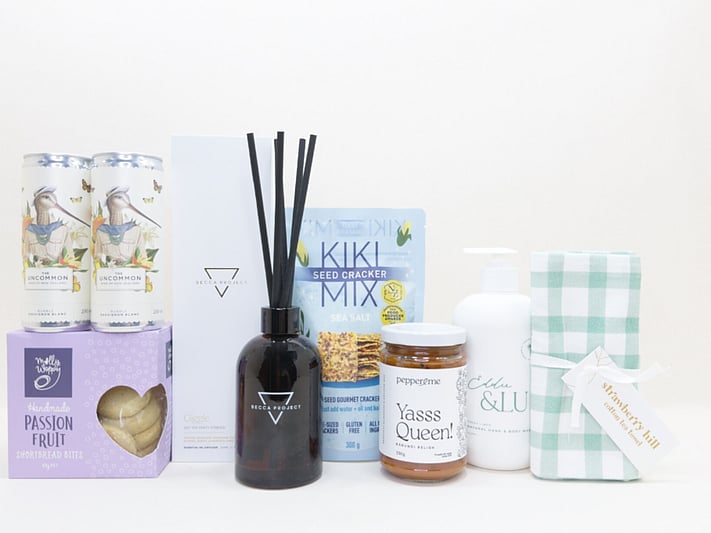 Home Treats Gift Box featuring Uncommon sparkling wine cans, Strawberry Hill tea towel, Kiki crackers, Yas Queen Relish, Molly Woppy cookies, Becca Project chocolate, and Eddy & lu home essentials.