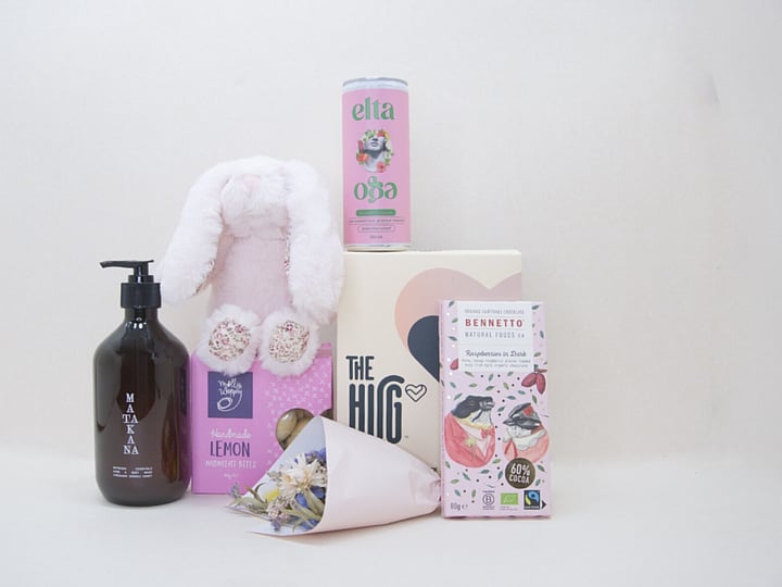 A Hug for Mum Gift Box featuring The HUG hot and cold gel pack, alcohol-free passionfruit cocktail, dried flowers, body wash, artisan chocolate, sweet treats, and a Lily & George teddy, beautifully presented in a premium KYND gift box.