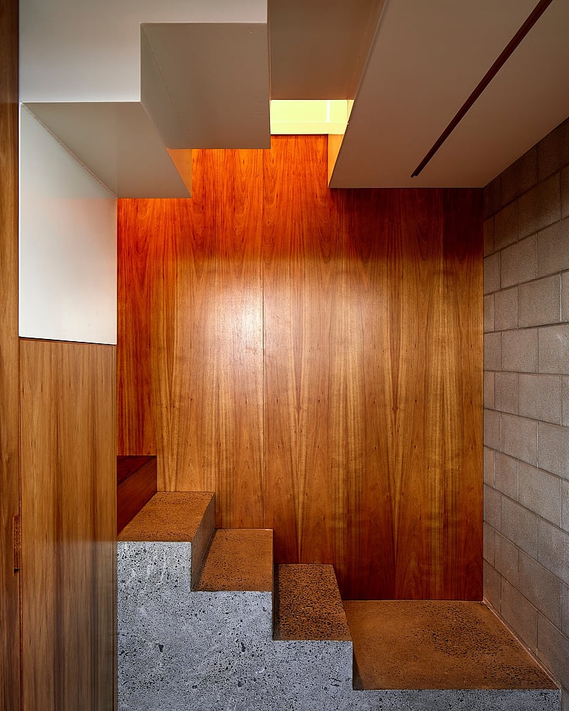 Home interior with wooden floor and ceiling and concrete walls.