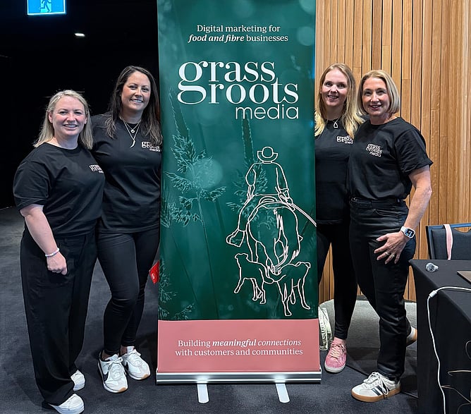 The Grass Roots Media team gathered around a branded backdrop at Te Pae