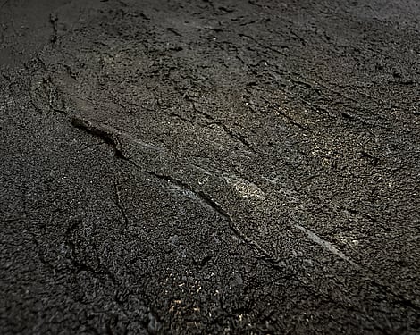 detail image showing heavily textured ridged surface with granular mineral texture, recessed pockets and softly blended caramel tones