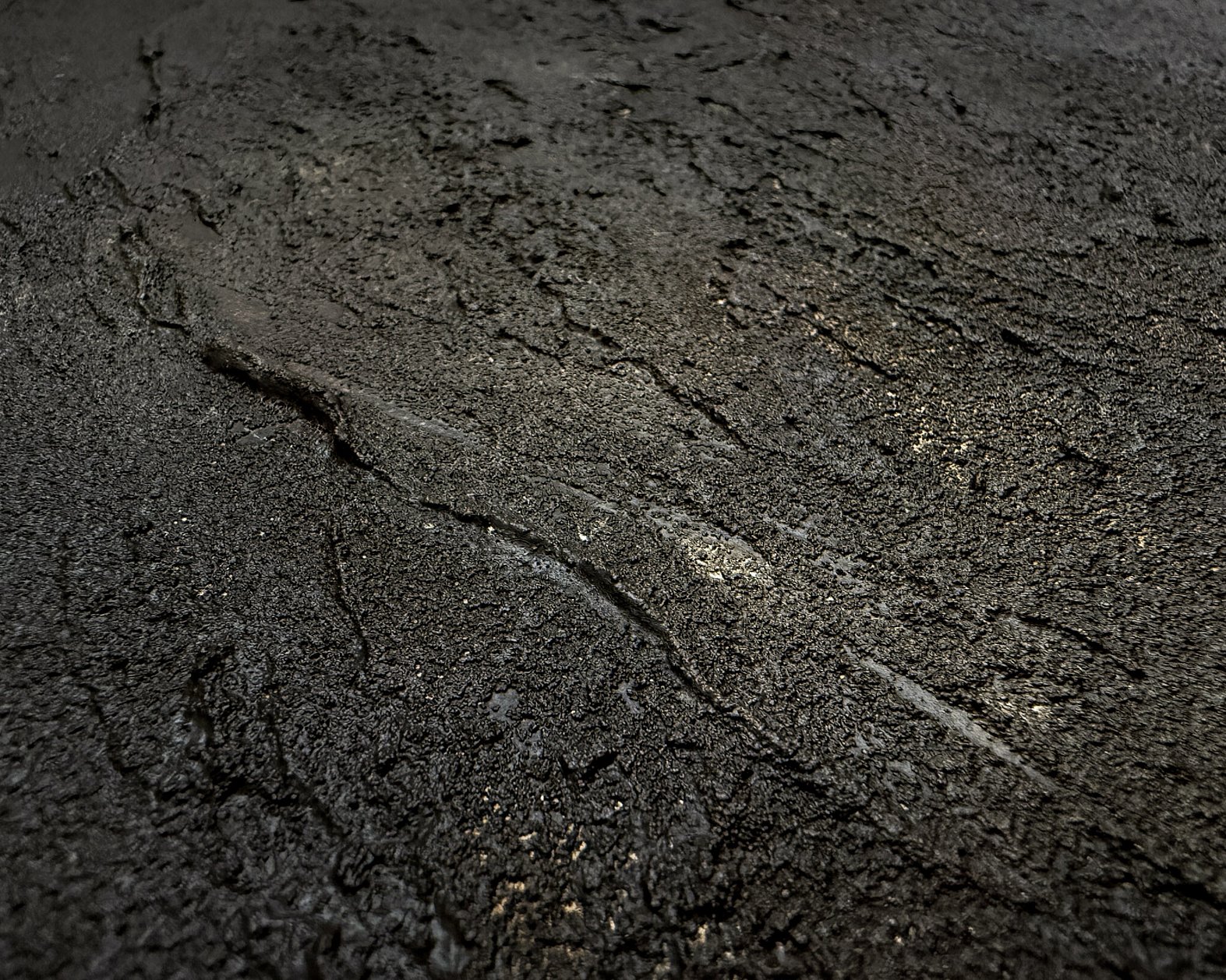 detail image showing a heavily textured deep cocoa-toned mineral surface with granular mineral texture, recessed pockets and softly blended caramel tones