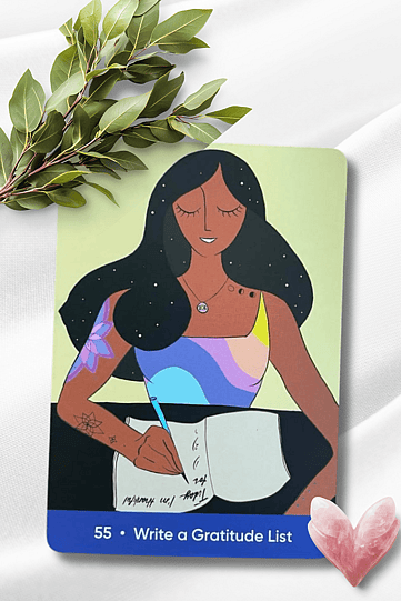 Write a Gratitude List Oracle Card from The Sacred Self-Care Oracle pictured on a white flowy background with greenery and a pink crystal