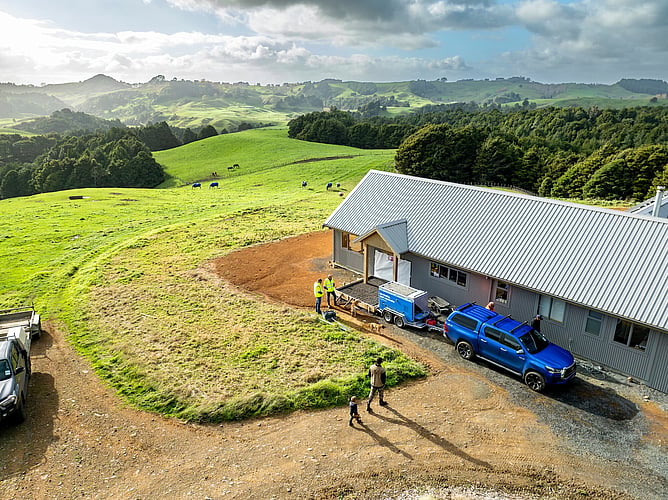 Crewmix CM1000 trailer mounted volumetric concrete plant backed up to prepped and boxed pad at a rural remote home