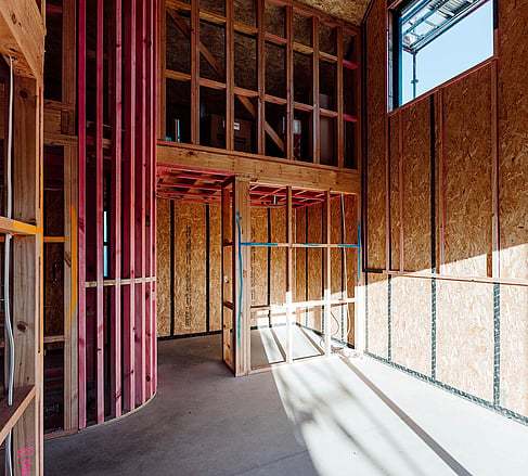 Mid-construction Ebode home interior showing structural framing before completion