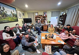 Image of students sitting around lounge table learning english