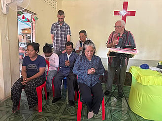 Discovery Mission team praying with Cambodian people