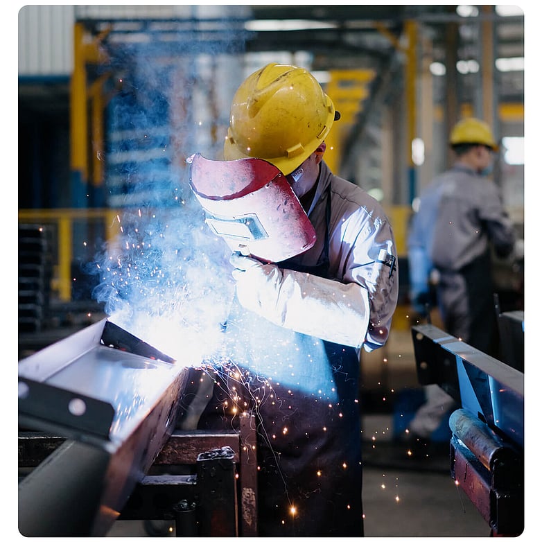 Welder working on a metal fabrication in a manufacturing workshop