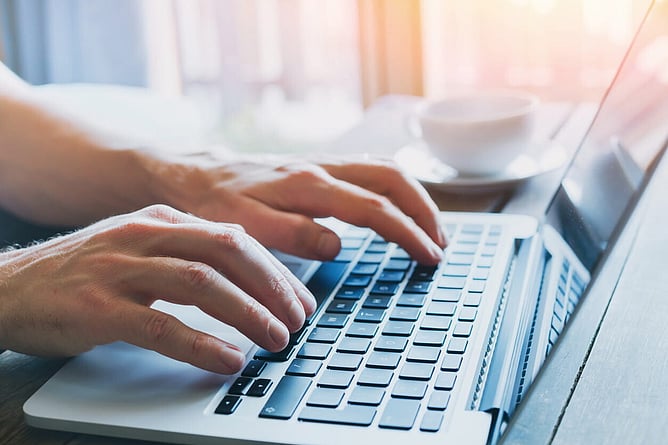 Person filling in their self assessment tax return form online at a laptop